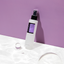 COSRX-AHA-BHA-Clarifying-Treatment-Toner on a purple wall background