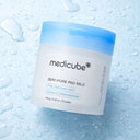 Medicube Zero Pore Pad Mild jar on a water droplet background