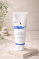 White tube of cream with blue label on a beige surface