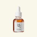 Bottle of skincare serum with dropper on a light beige background