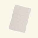 Sheet of round white stickers on a light gray background