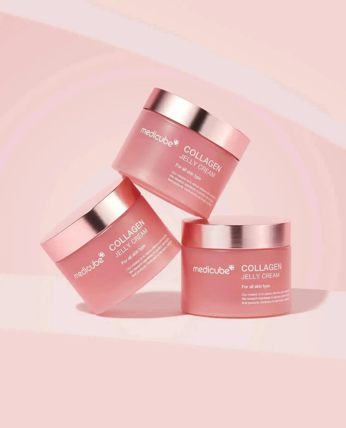 Three pink Medicube Collagen Jelly Cream jars arranged against a pink background