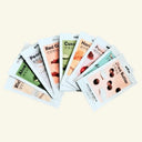 Assorted skincare mask packets on a beige background